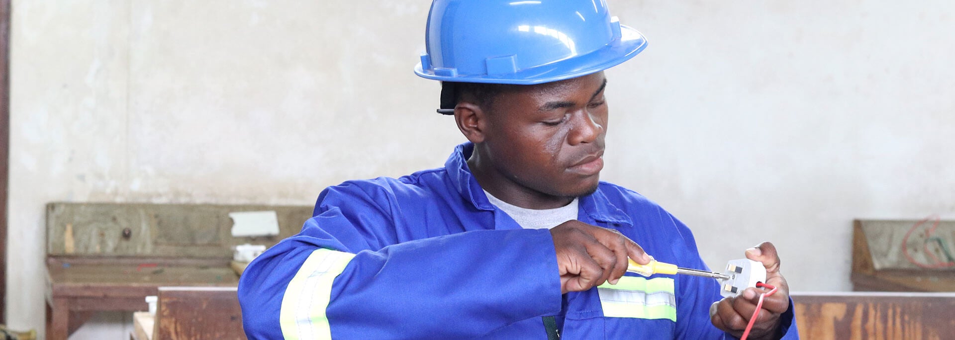 
		Man working on a small device with a screwdriver		